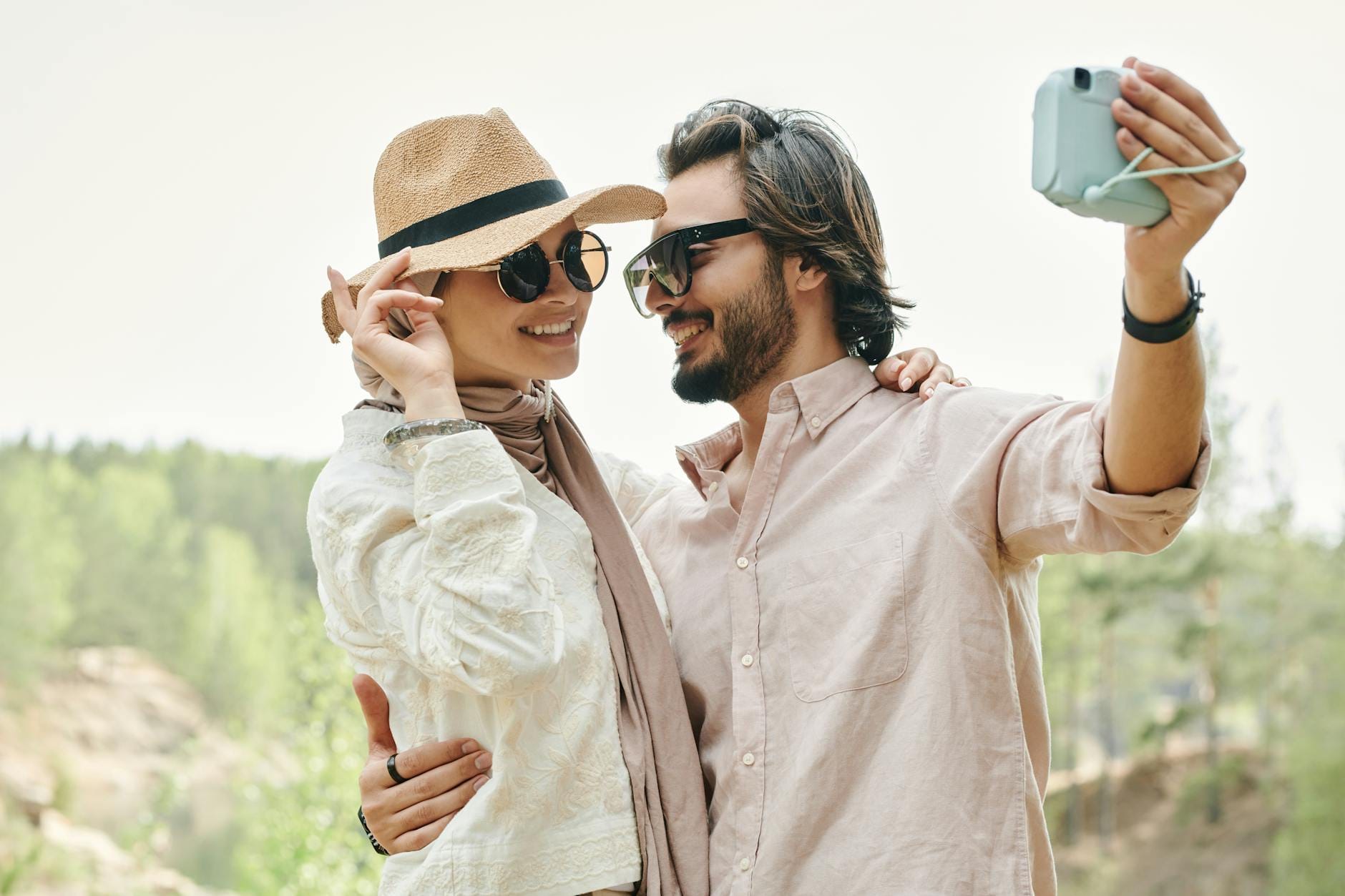 Para w okularach przeciwsłonecznych robi selfie w słoneczny dzień