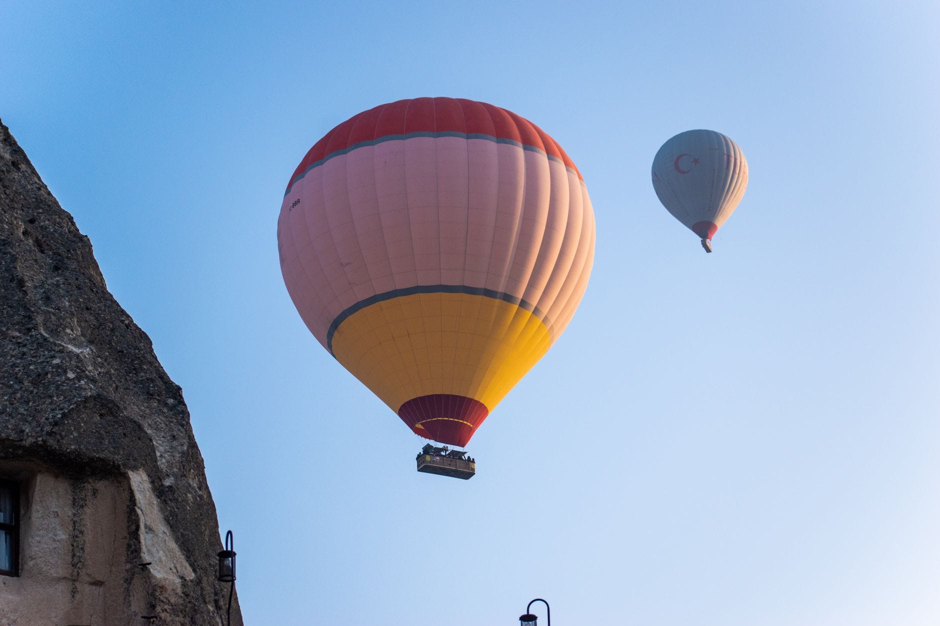 Dwa kolorowe balony nad skalistym krajobrazem Kapadocji