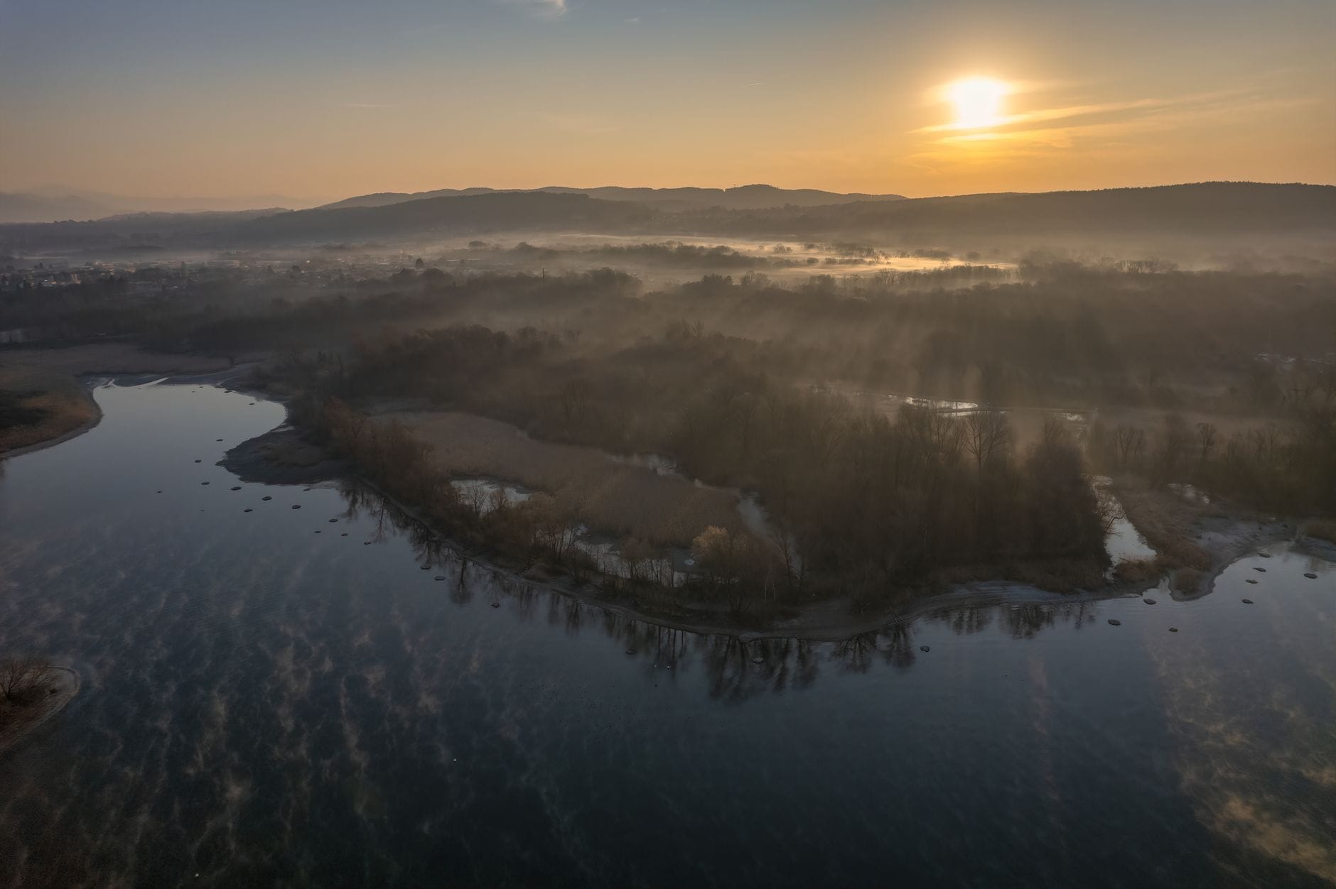Widok z lotu ptaka na spokojne jezioro i poranne mgły o świcie